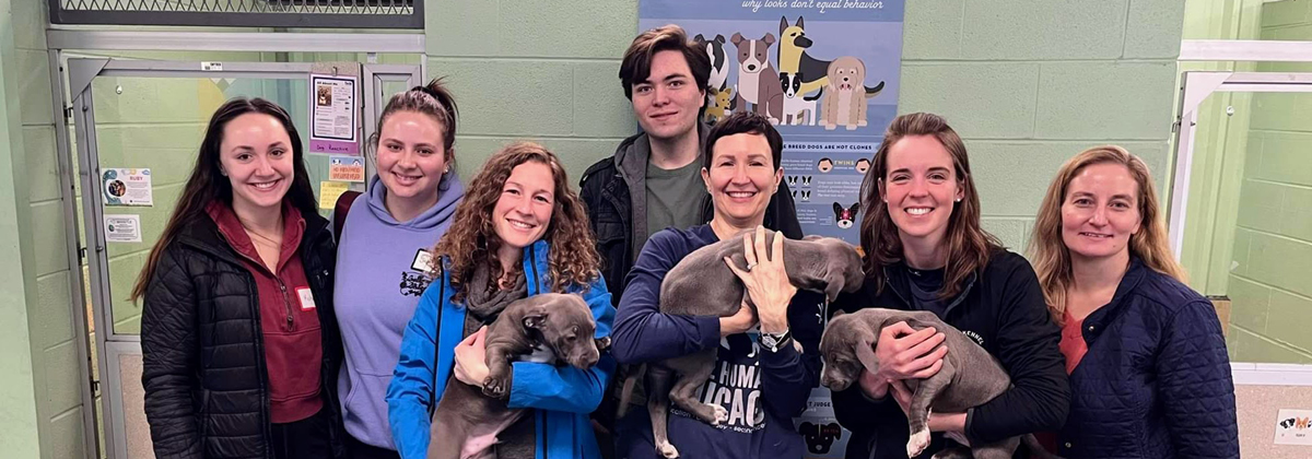 Professor Kerri Burchfield and students pose with dogs